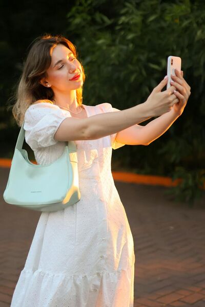 A beautiful girl standing and looking at her smartphone
