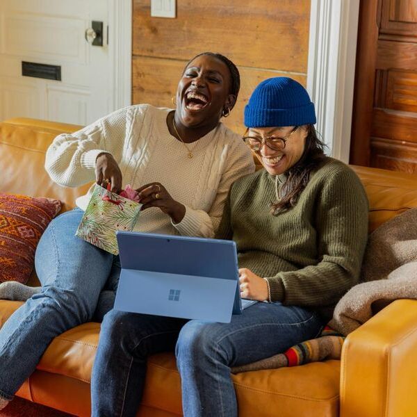 Image of people happily using the Peer app while sitting cozy on a sofa